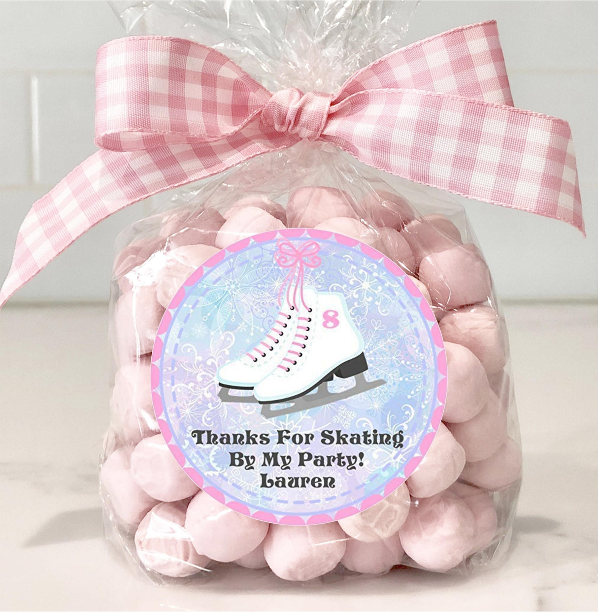 Ice skates party favor sticker in pink winter theme
