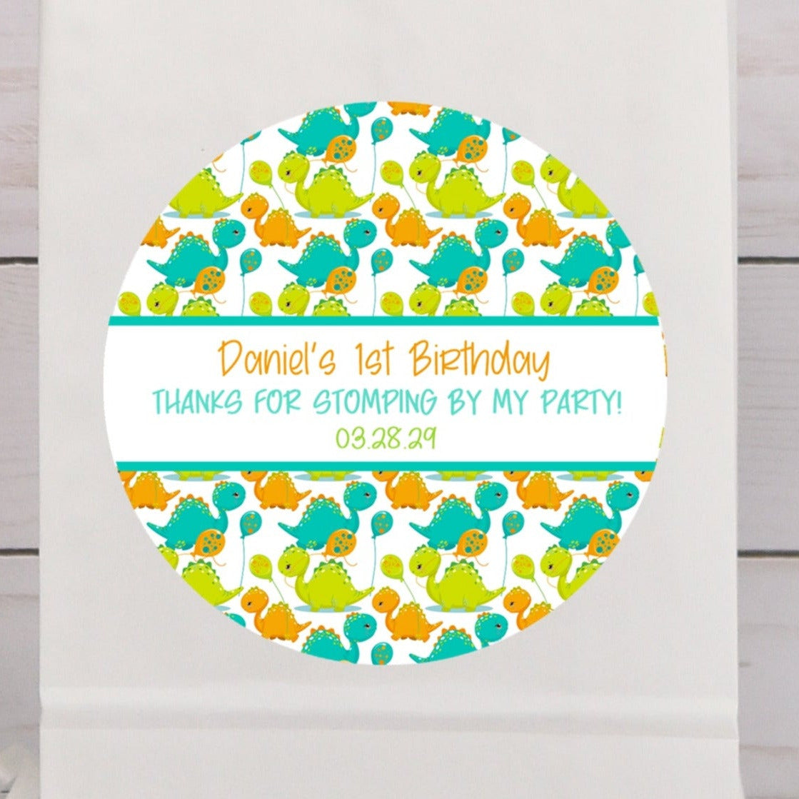 Cute dinosaur birthday sticker with teal and orange baby dinosaurs