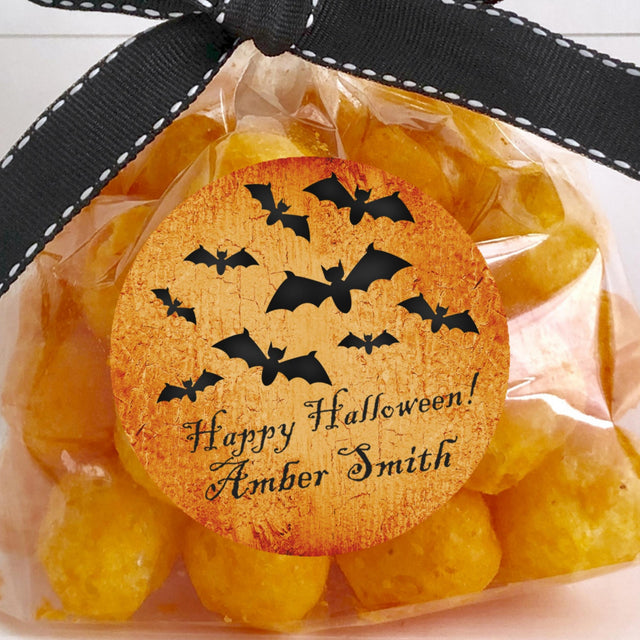 personalized halloween sticker with flying bats over textured orange surface